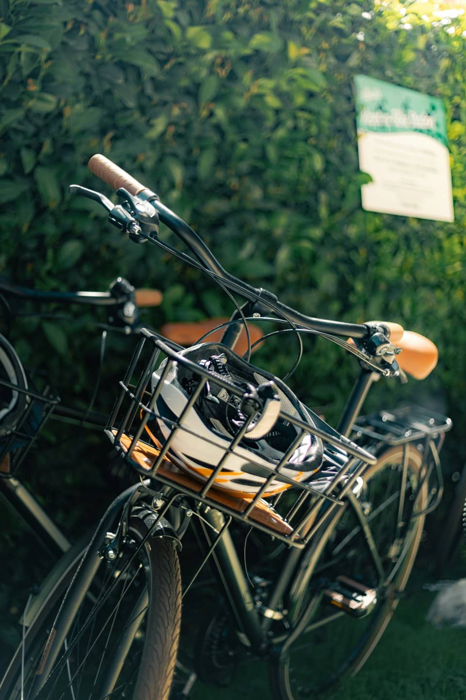Zwei geparkte Fahrräder mit einem Helm im Korb.