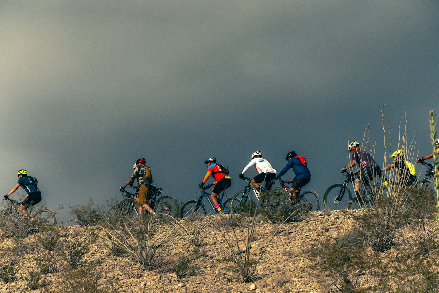 Mountainbiker fahren auf einem felsigen Wüstenpfad bergauf.